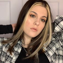 A woman with long brown hair with blonde streaks around her face