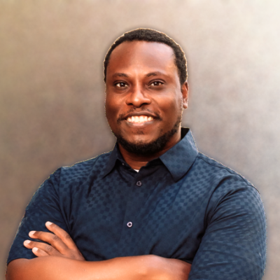 a man with his arms folded smiling at the camera