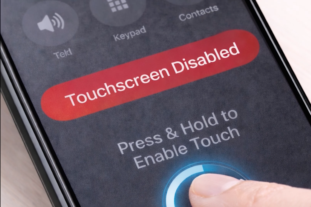 a finger touches presses the screen of a mobile phone in a an app to disable a touch screen